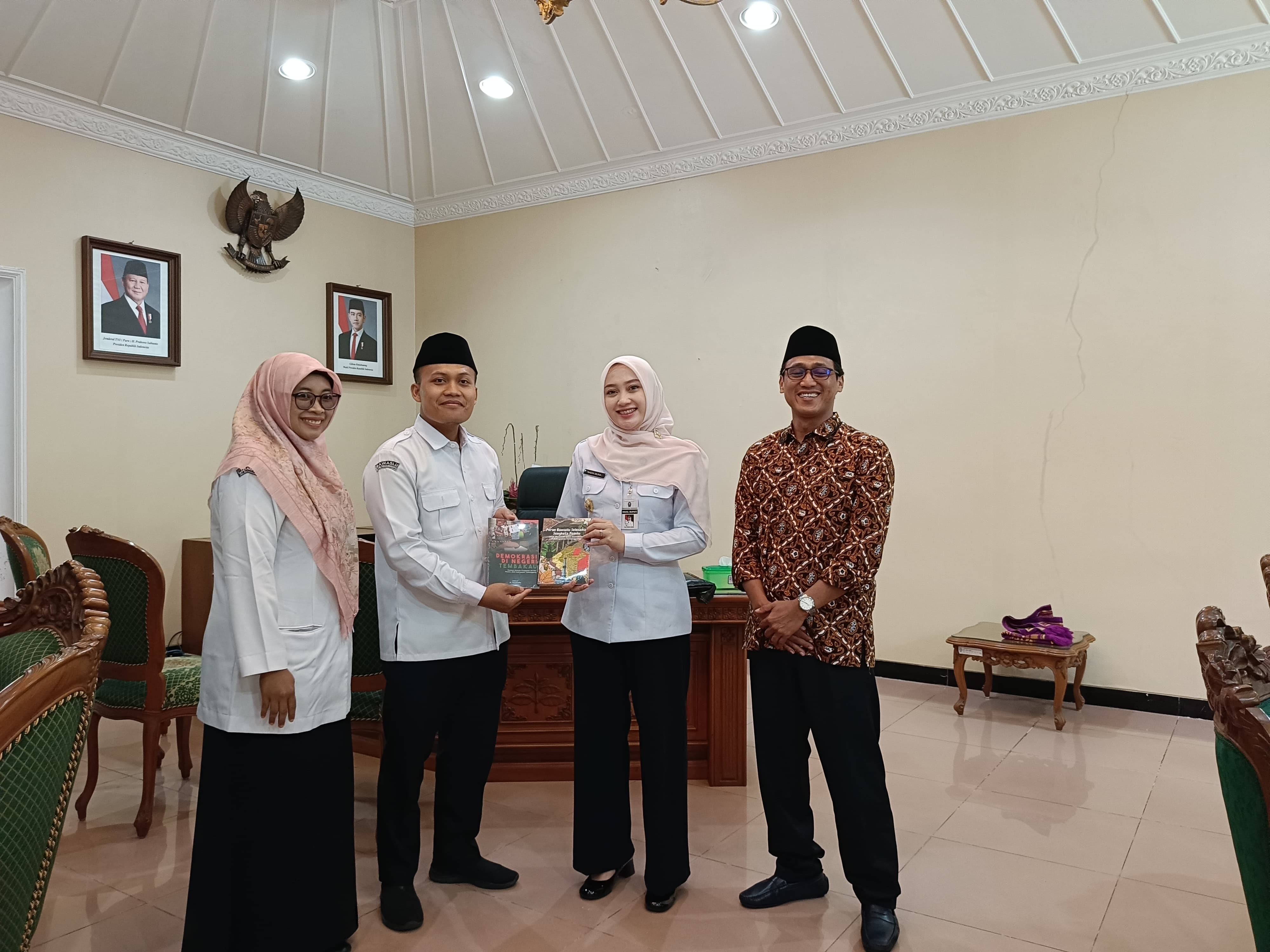 Penyerahan buku hasil kinerja Bawaslu dan buku SDM.